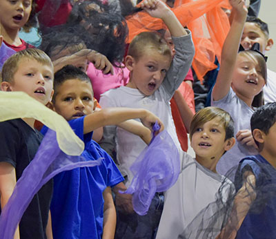 kids waving scarves on choir risers