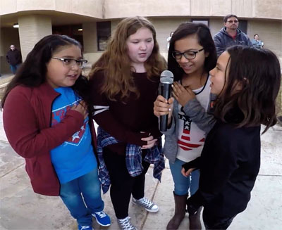 four students with a microphone