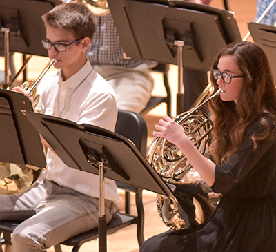 two students playing french horn