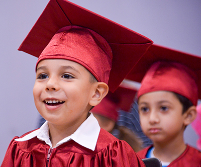 kid in cap an gown smling