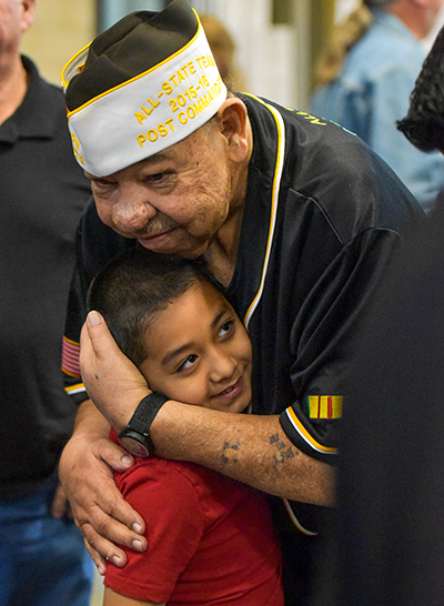 man in uniform hugging child