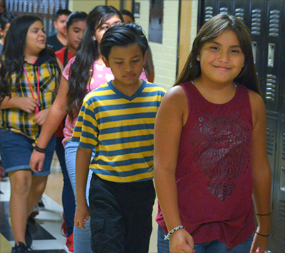 kids walking down hall smiling