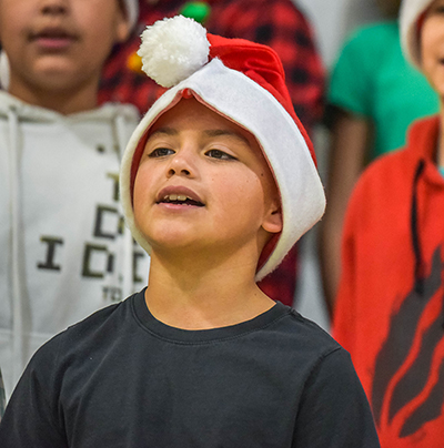 kid in santa hat singing