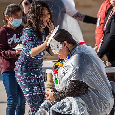 girl putting pie on teacher's head