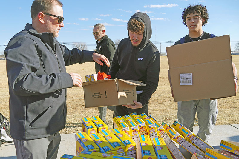 coach with players loading food boxes